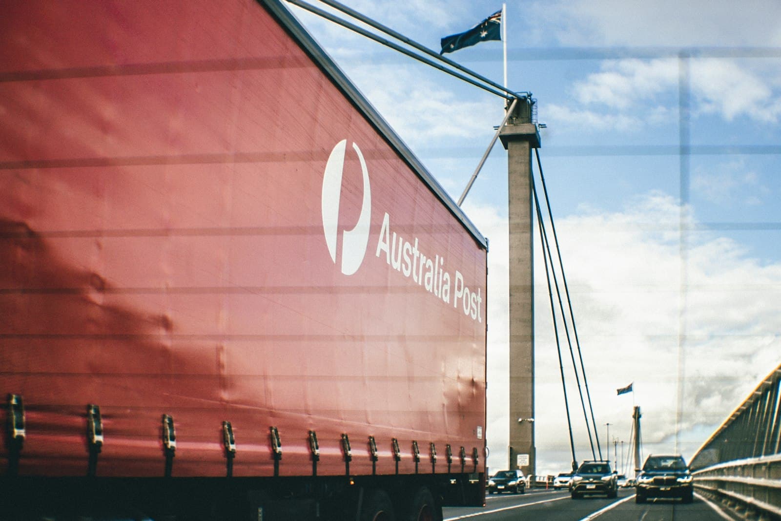 A large red boat sitting beside a road in Australia.